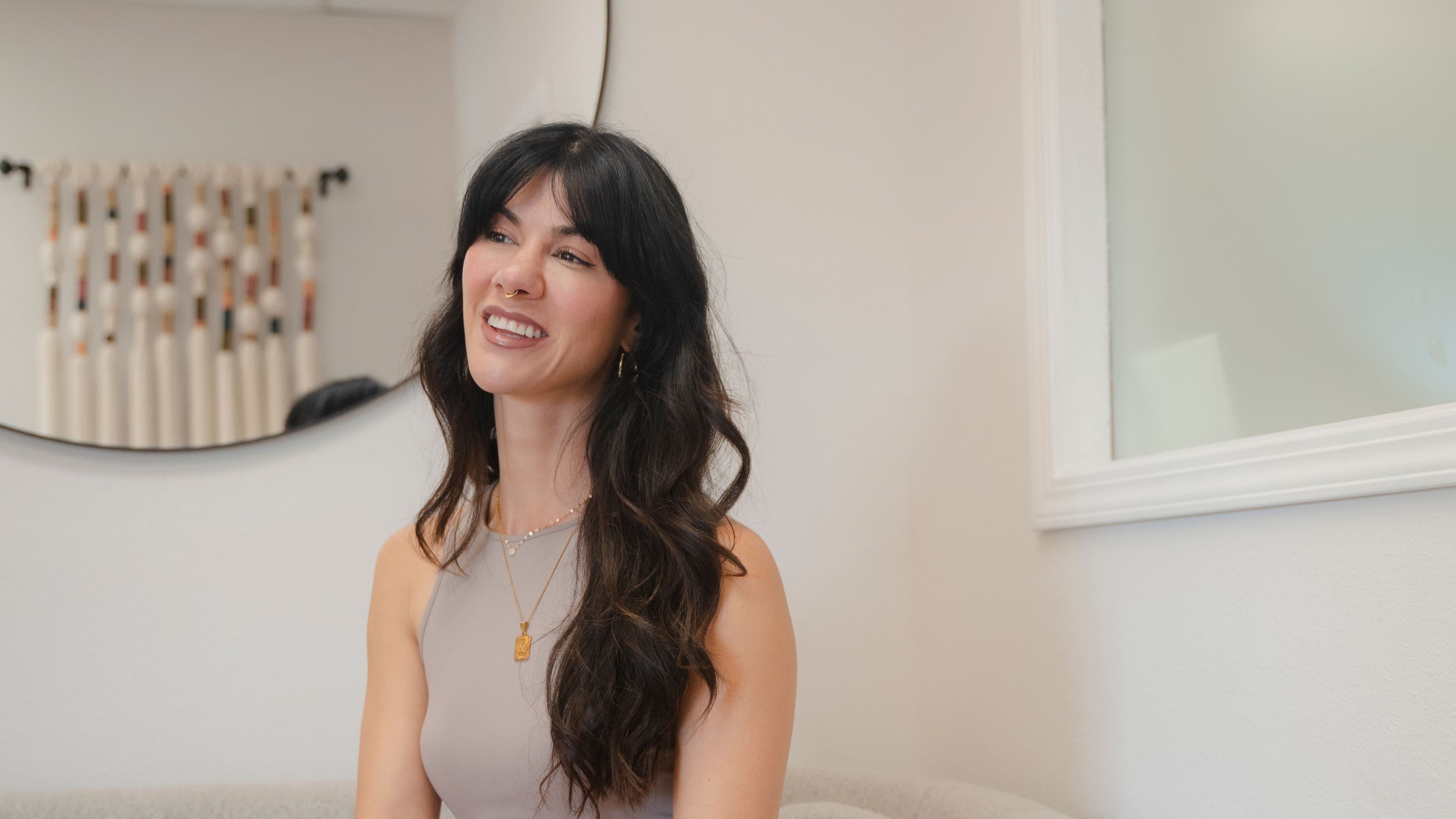 woman sitting on couch smiling looking off to the left